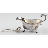 A hallmarked silver sauce boat, raised on four hoof feet, together with a hallmarked silver small