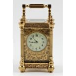 A small brass carriage clock with floral fret work design throughout and five glass panels, approx