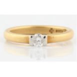 A hallmarked 18ct yellow gold diamond solitaire ring, bar set with a round brilliant cut diamond,
