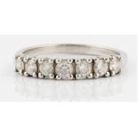 A hallmarked platinum seven stone diamond ring, set with seven round brilliant cut diamonds, total