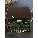 A two drawer canteen of cutlery raised on cabriole legs, containing an eight place setting canteen