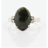 A green hardstone and diamond ring, set with an oval green hardstone cabochon, measuring approx.