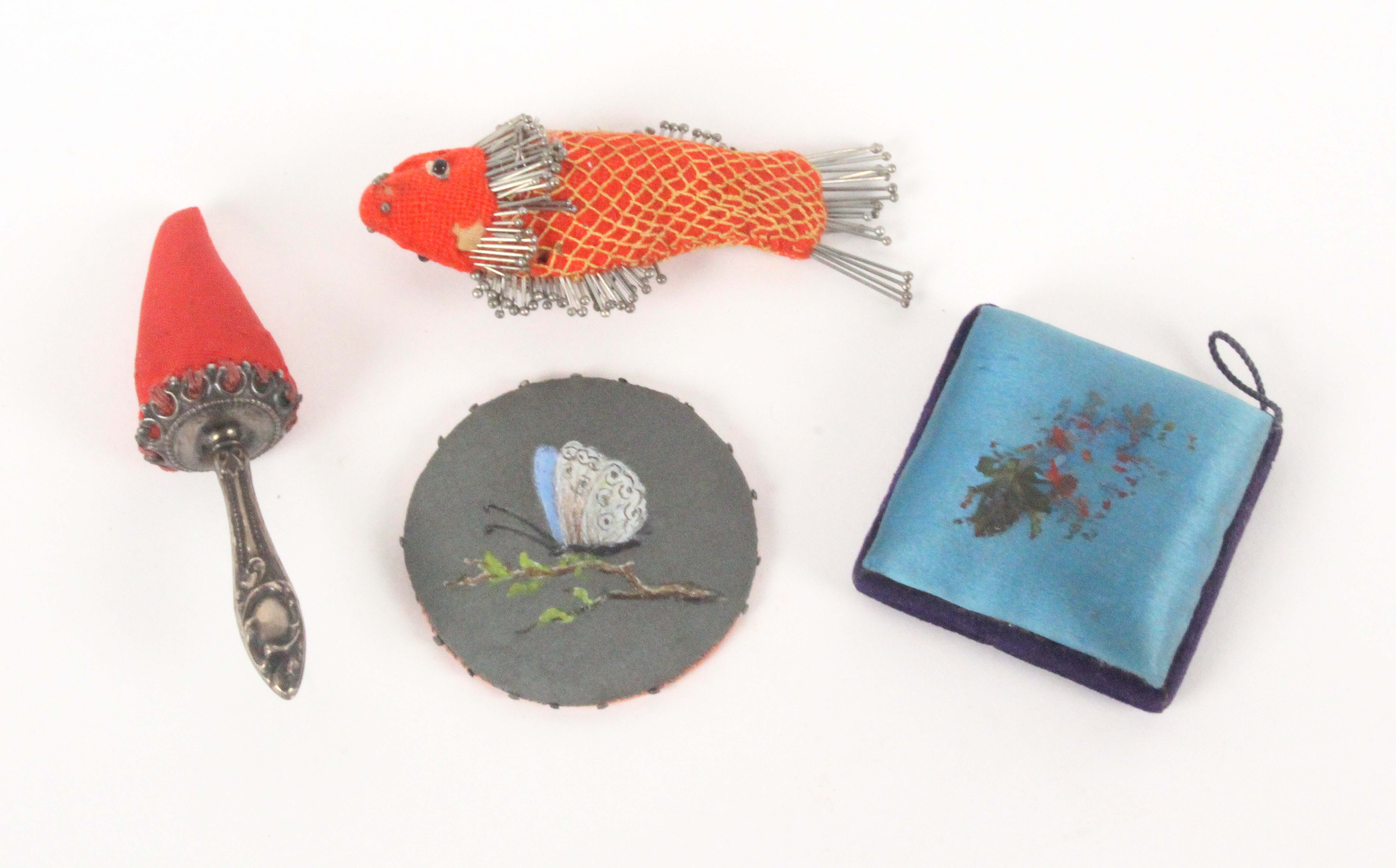 Four pin cushions, comprising a red material example pin stuck as a fish, a little moth, 8.5cms,