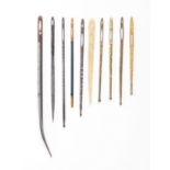 Eight bodkins and two needles, comprising four brass and gilt brass decorated fish form examples,