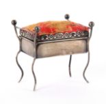 An unusual silver pin cushion in the form of a piano stool, with worn silk hinged seat within a