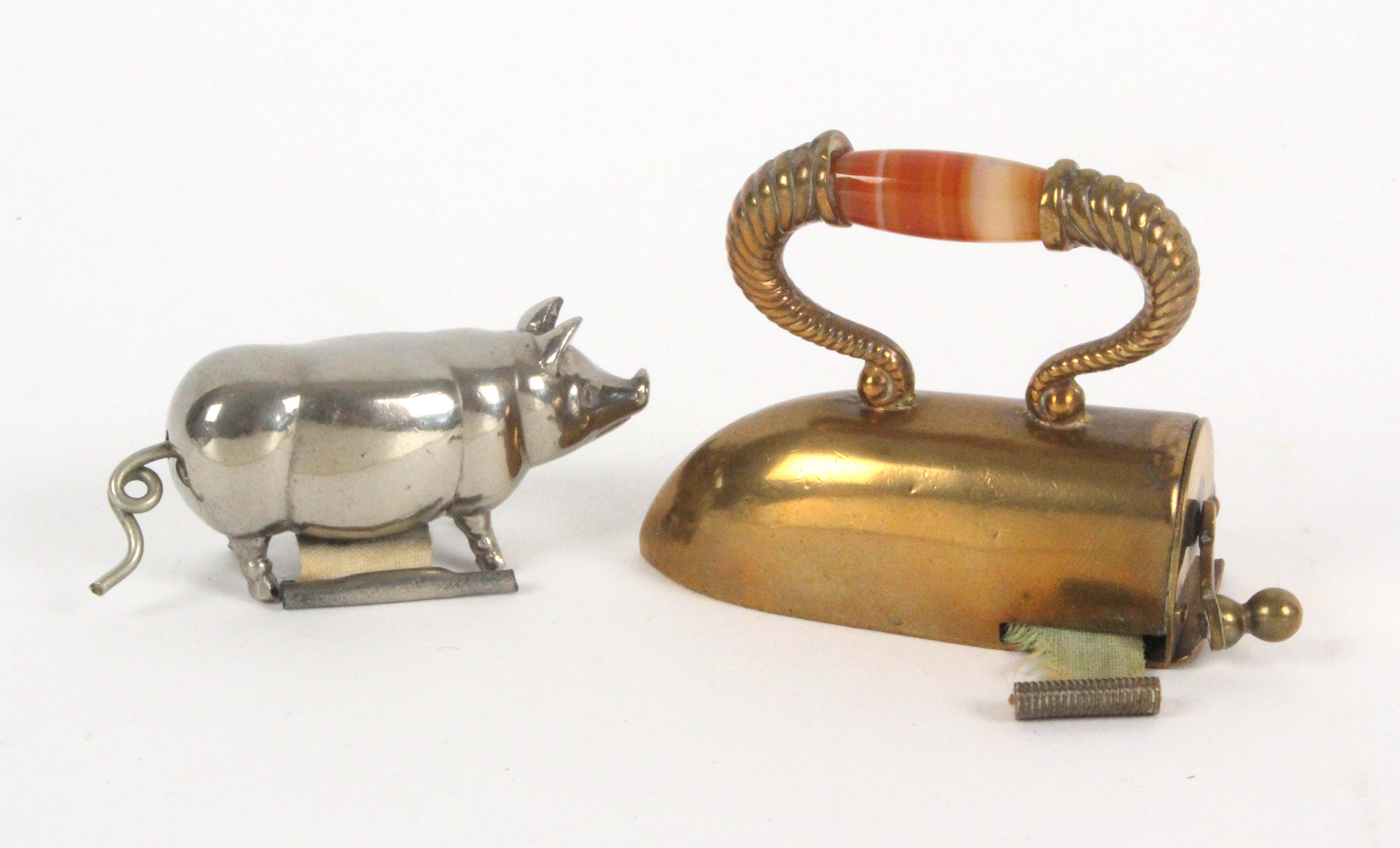 Two novelty tape measures, comprising a standing pig in white metal, the complete printed tape in