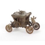 A brass novelty tape measure in the form of the Coronation coach, the printed tape in ins. and