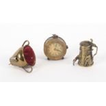 Three novelty tape measures, comprising a brass example in the form of a beer stein, reduced printed