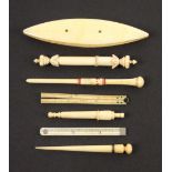 Seven 19th Century ivory sewing tools, comprising a shuttle, 12cms, two needle cases one with