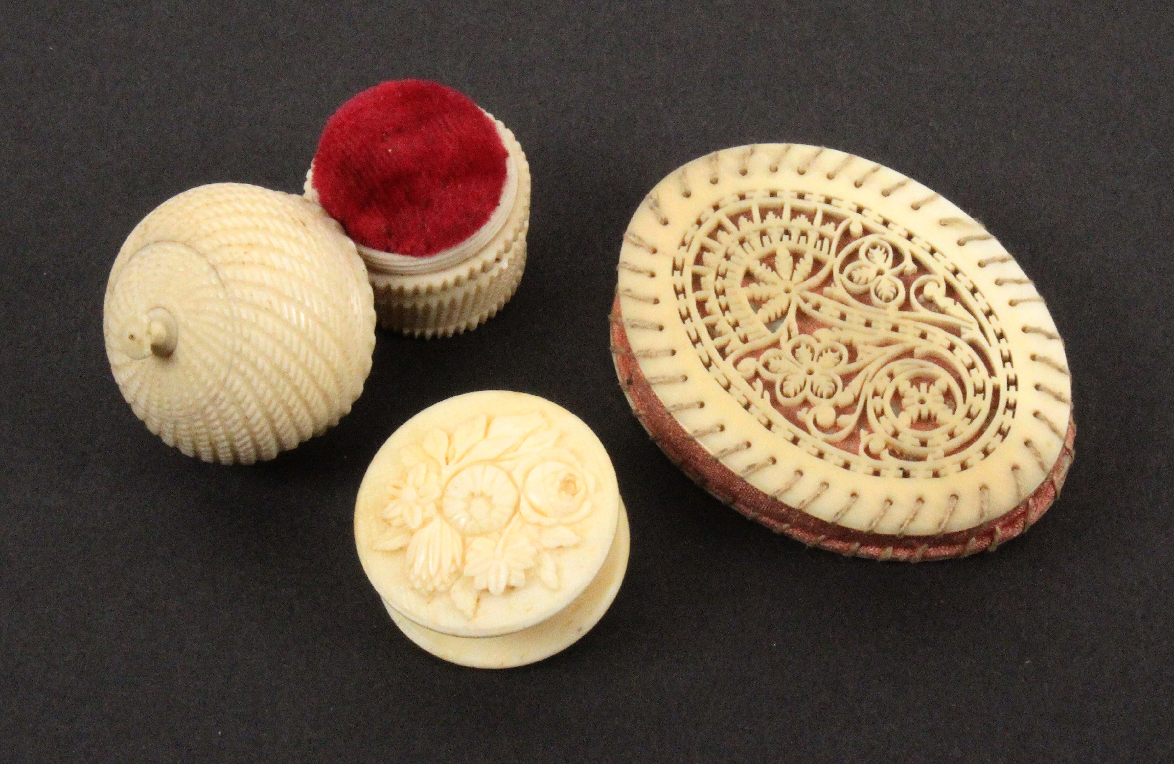 Two 19th Century ivory pin cushions and a waxer, comprising an oval pin cushion with finely