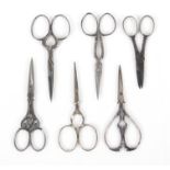 Six pairs of 19th Century steel scissors, all with decorative arms or loops, largest 9cms, and