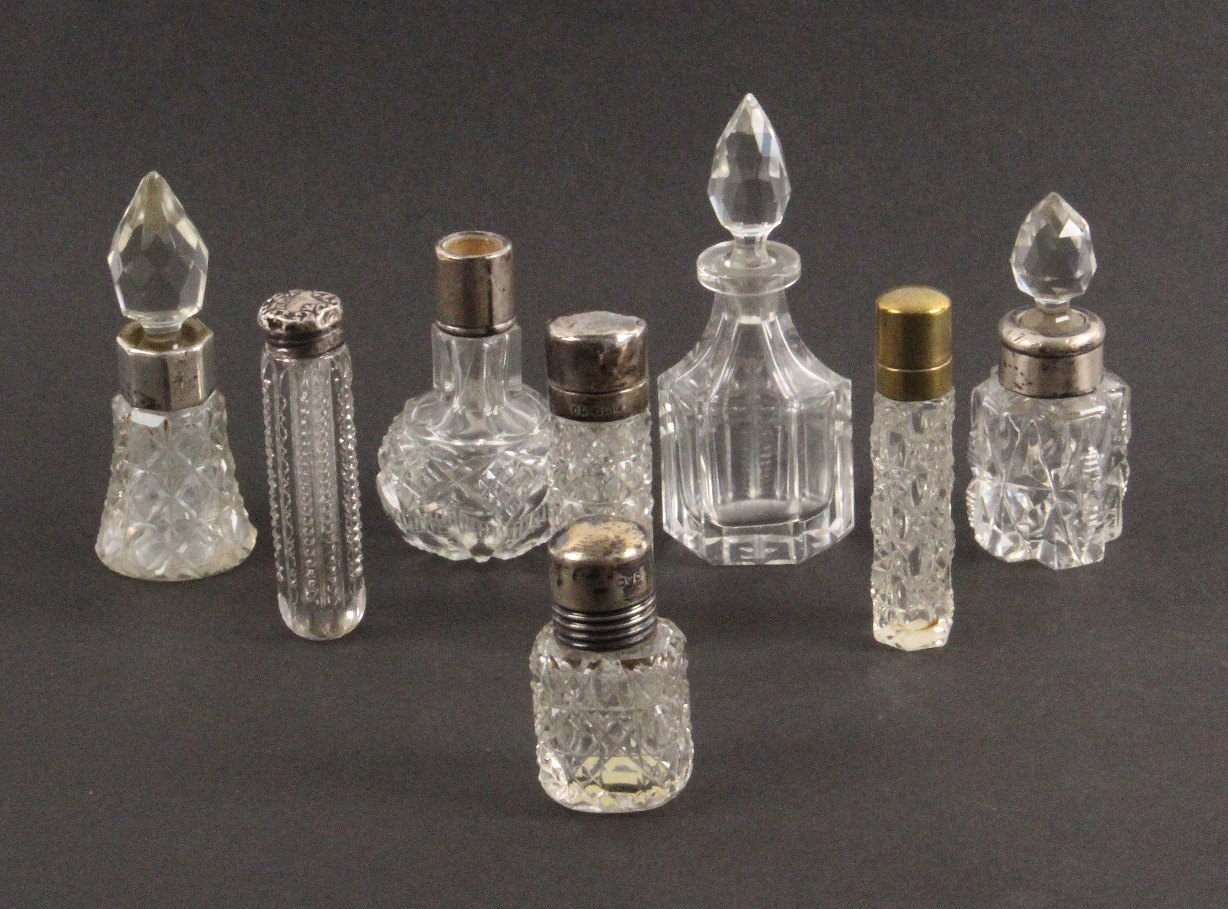 Eight early 20th Century cut glass scent and other bottles, six with hall marked silver mounts or