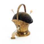 A gilt brass novelty tape measure in the form of a basket, incorporating a pin cushion, the