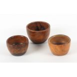Three 19th Century lignum vitae wool ball bowls, largest 7.5cms, smallest 6cms.    (3)