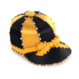 A good example of a jockey cap pin cushion, in alternate panels of gold and black silk with pin