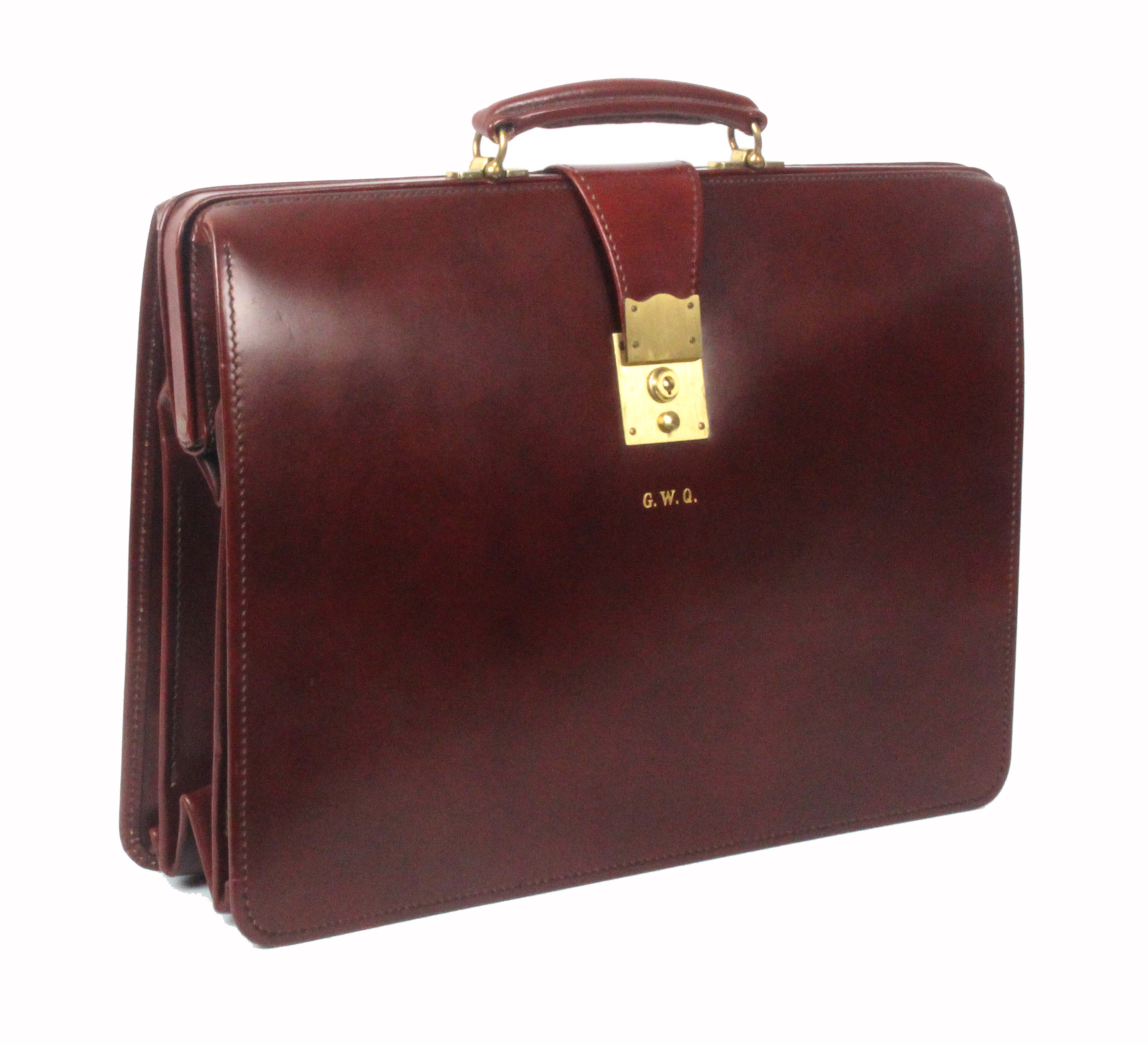 Asprey - London, a burgundy leather brief case, unused, initialled 'GWQ', brass lock, internal