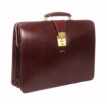 Asprey - London, a burgundy leather brief case, unused, initialled 'GWQ', brass lock, internal