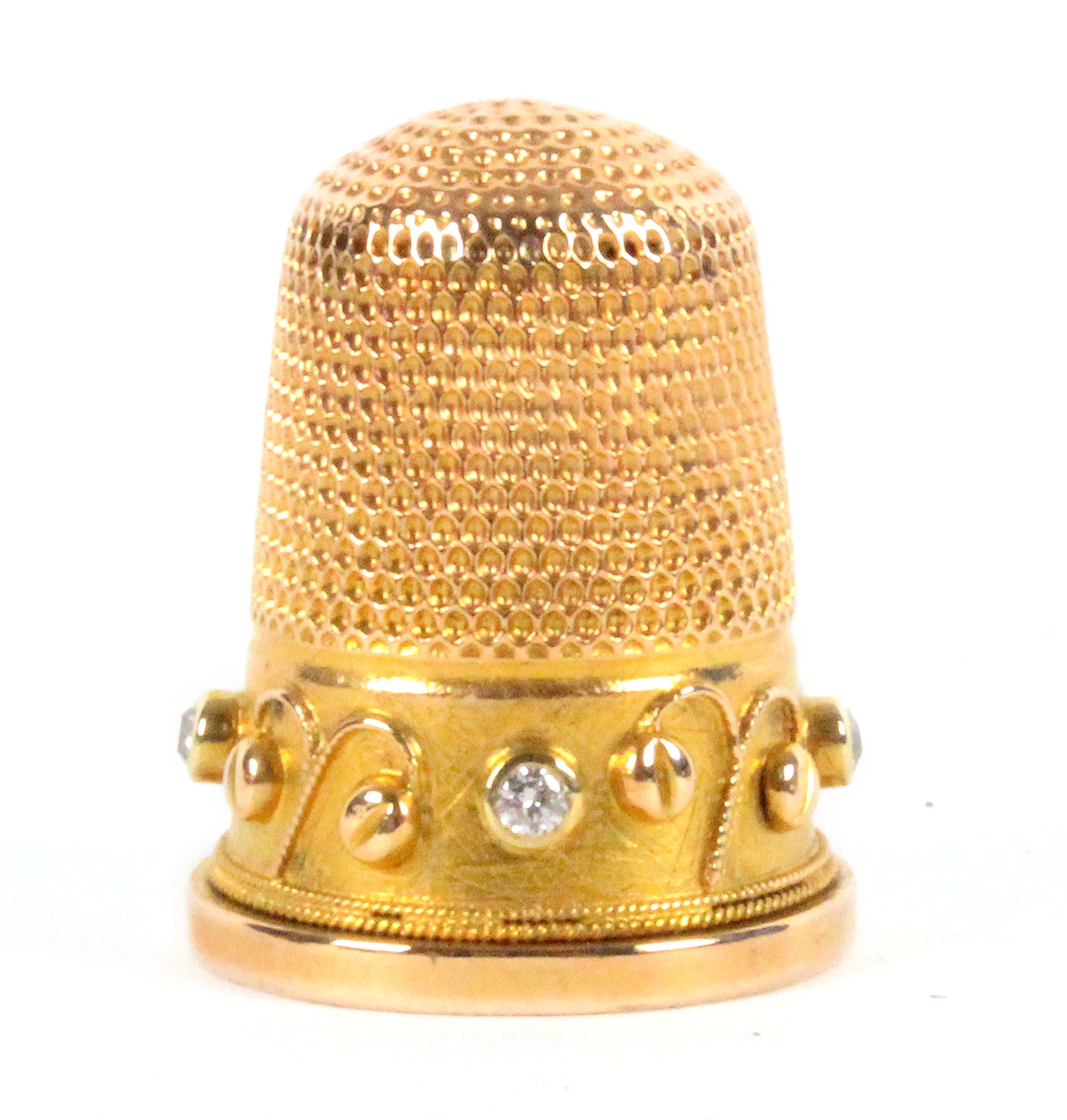 A late 19th Century gold thimble, the frieze set with four diamonds divided by fruiting branches