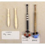 A card display of four lace bobbins, two in ivory or bone, 7cms, a modern ebony and silver example