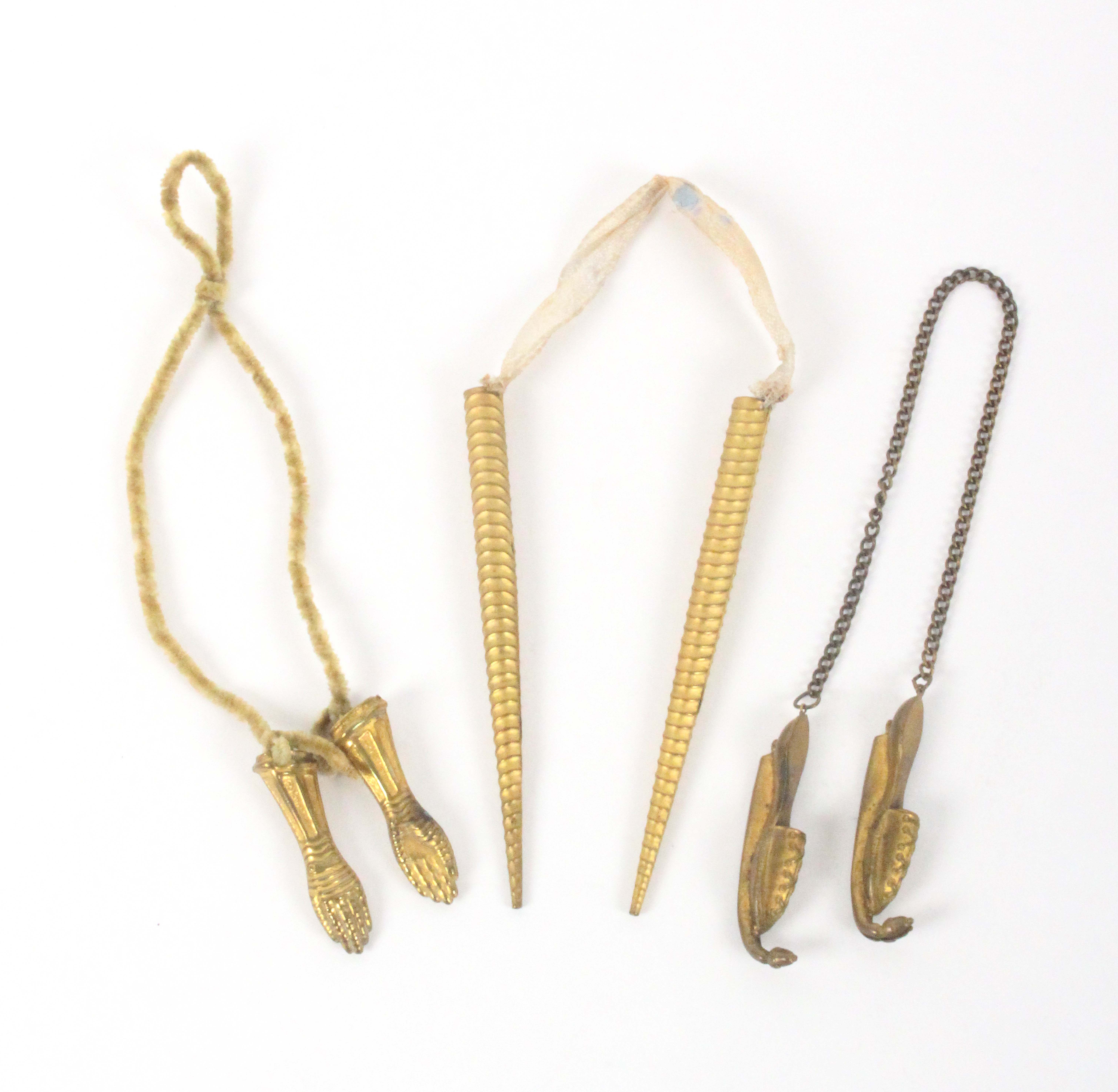 Three pairs of gilt metal knitting needle protectors, comprising a pair formed as lady's ice skates,