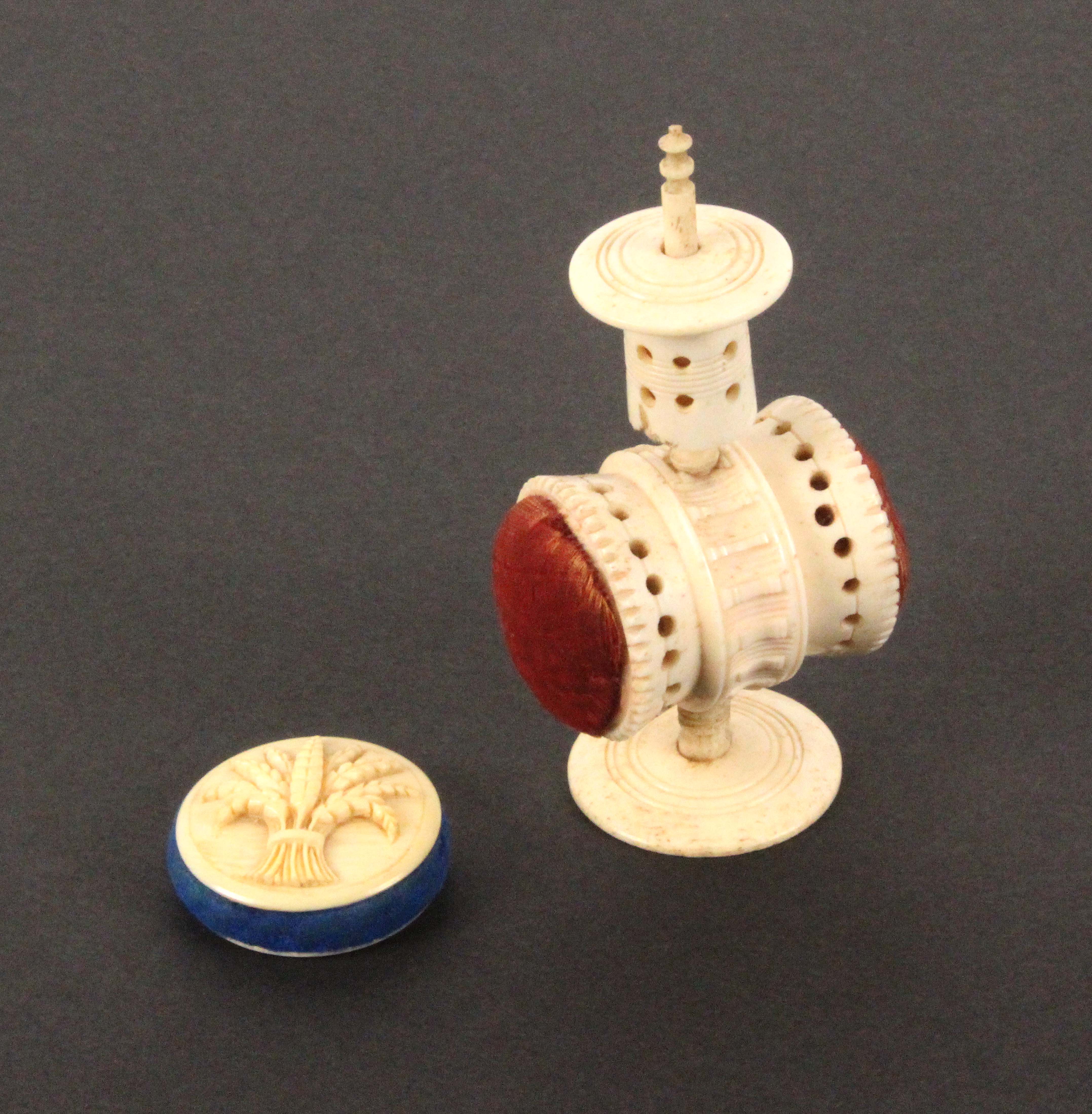 A combination pin cushion/tape measure and another pin cushion, the first in bone of pedestal form