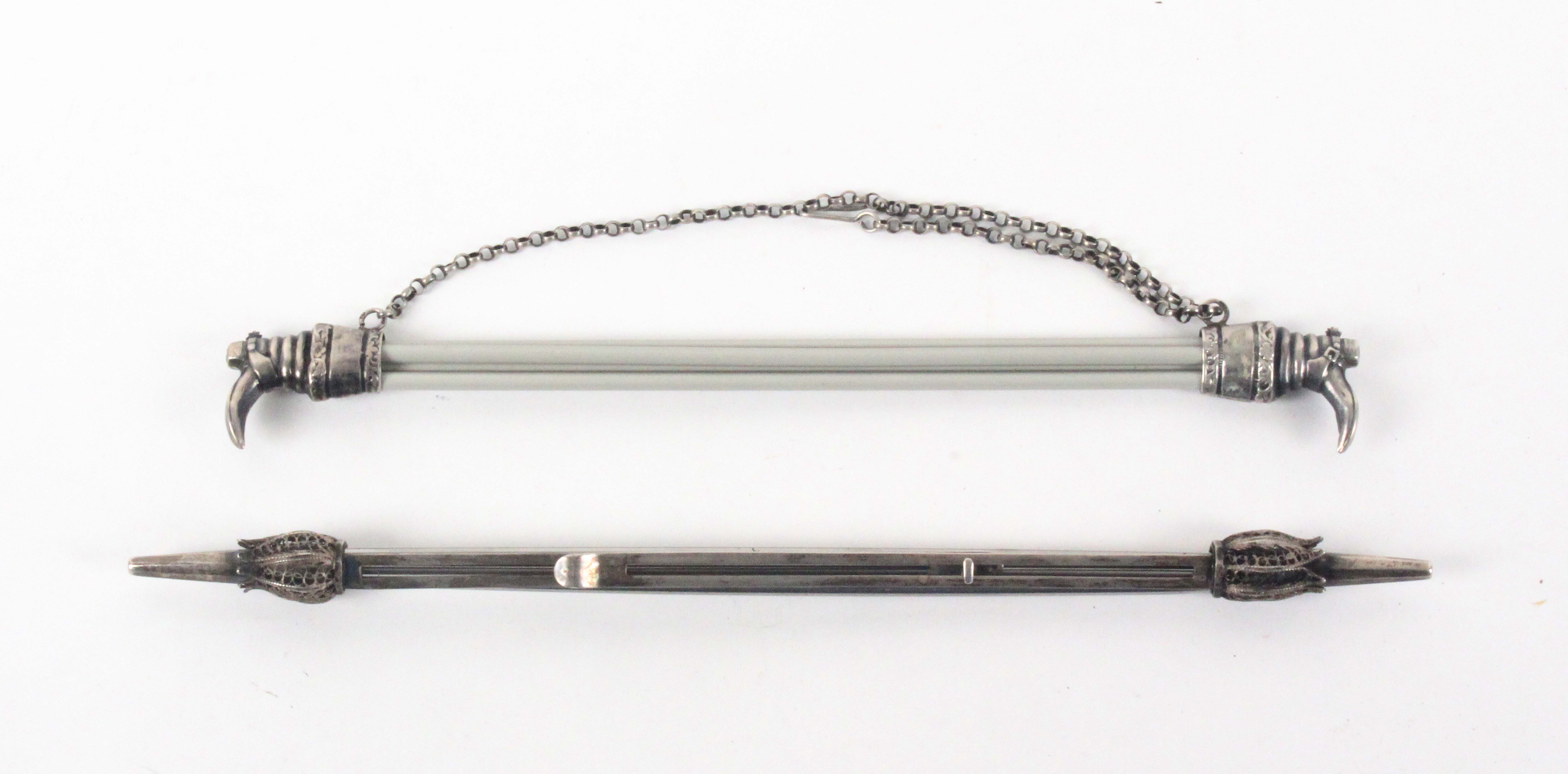 Two knitting needle holders, comprising a continental silver example of sliding form each pointed