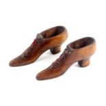 A pair of late 19th Century shoe form table snuff boxes, carved toe cap divide and lace surrounds,