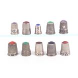 Ten late 19th Century/early 20th Century continental silver thimbles, with inset stone tops mostly