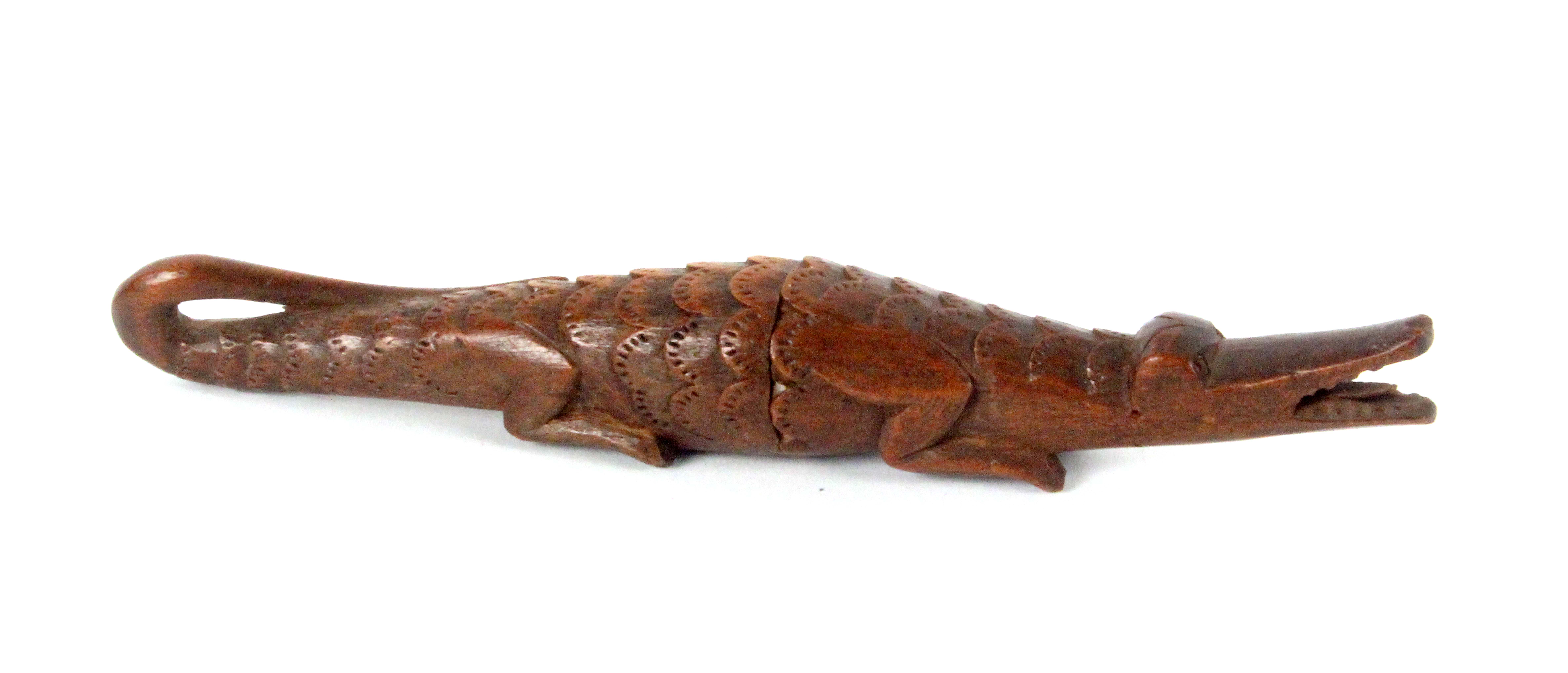 A scarce carved wooden needle case in the form of a crocodile, open jaw, the tail curling back