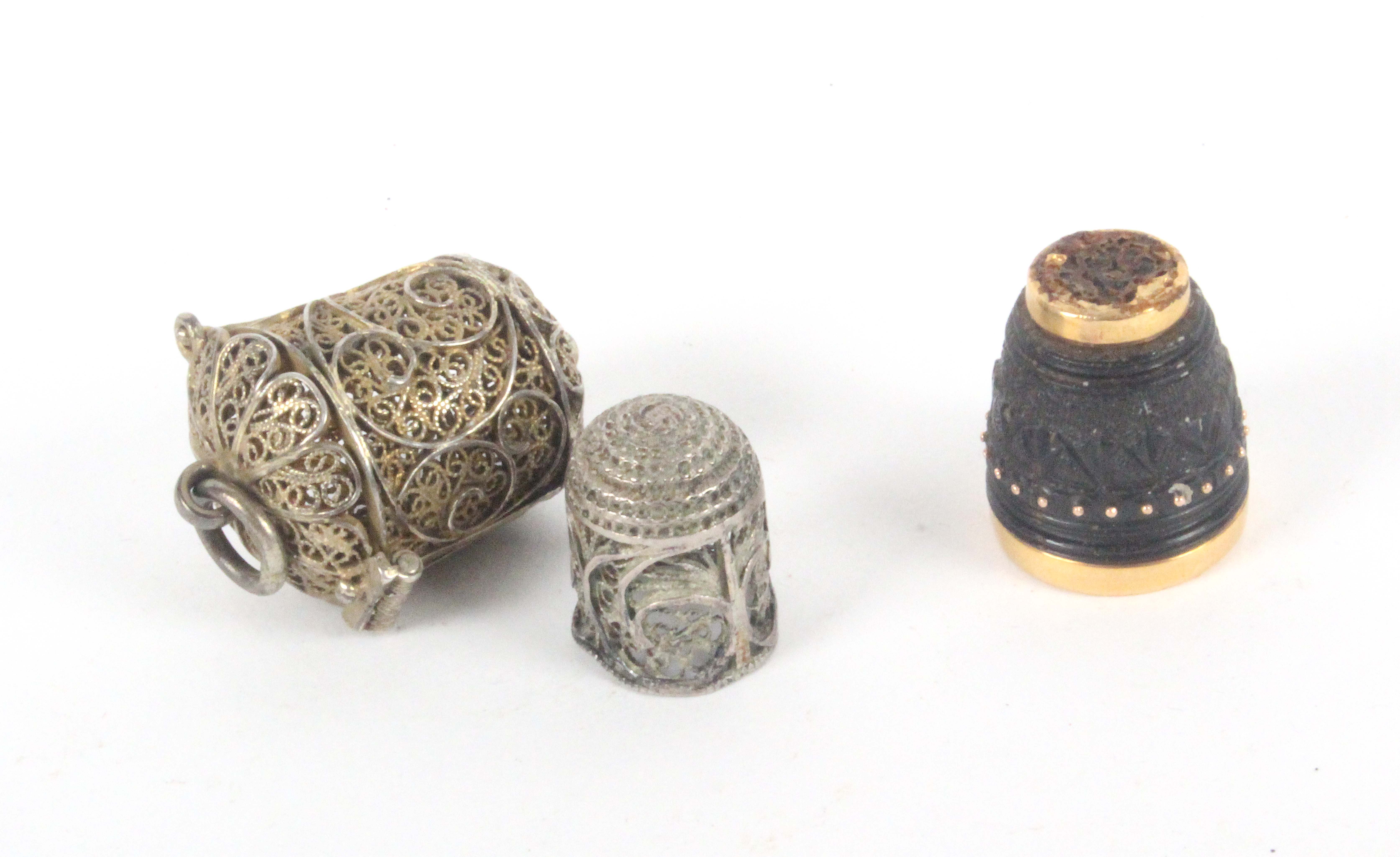 An 18th Century silver filigree thimble in case and a coquilla thimble, the first of small size with