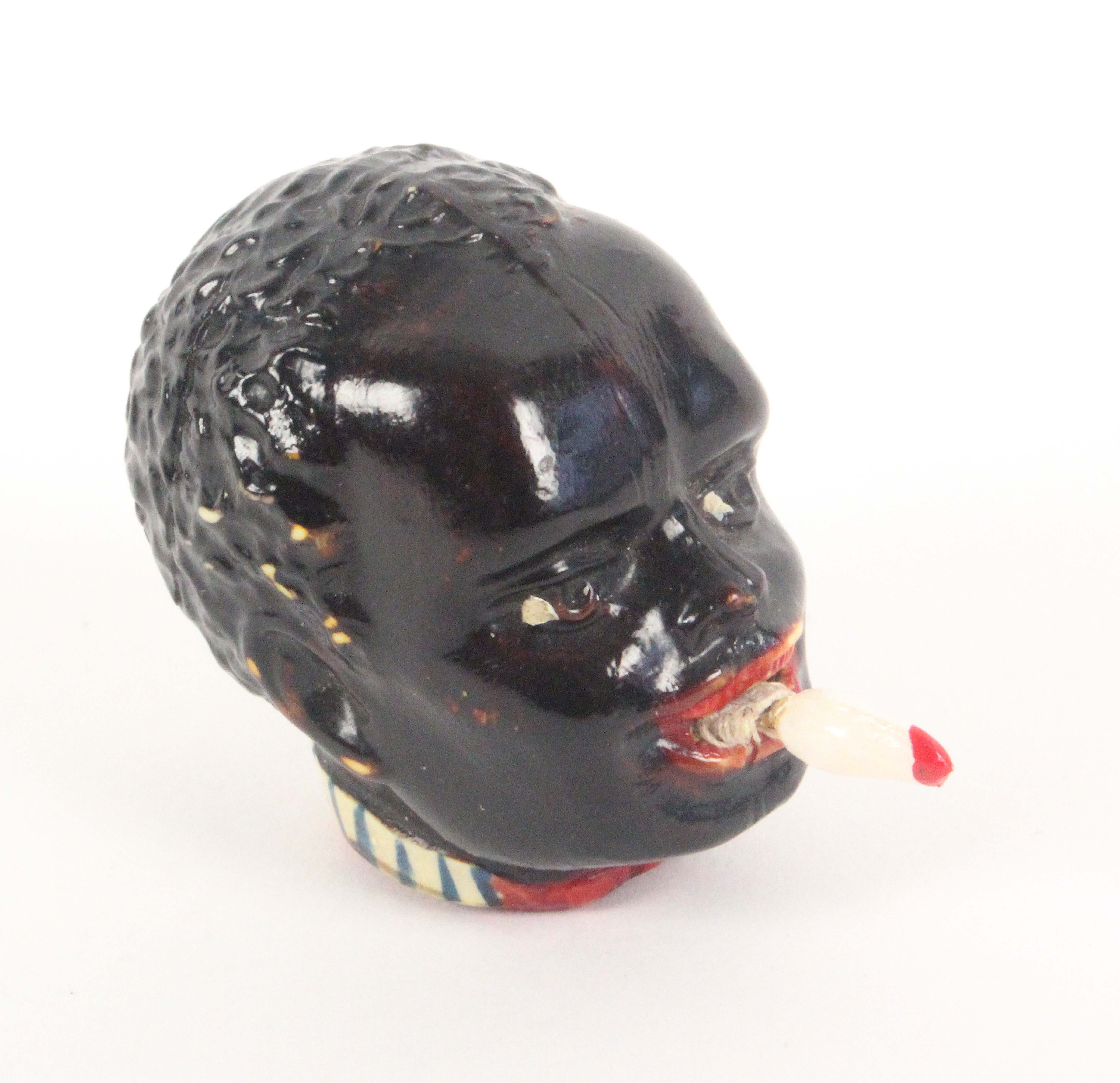 A novelty celluloid tape measure, in the form of a black boys head, the tape emerging from his mouth