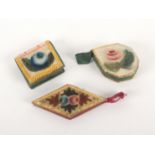 Three painted velvet pin cushions and emeries, comprising a diamond shaped example with embossed