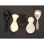 Five caddy spoons, comprising a mother of pearl example with carved handle, 7.5cms, a pressed