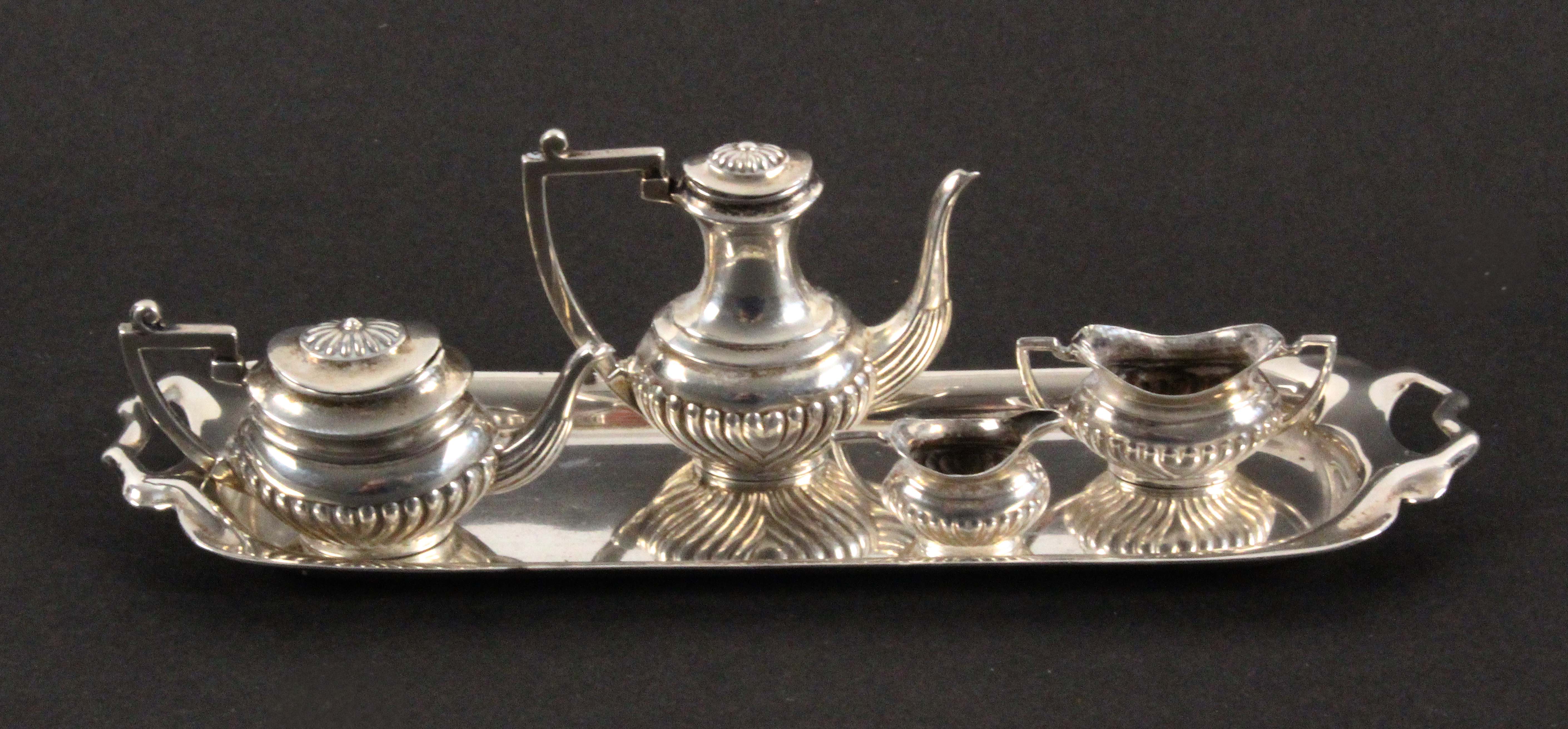 A miniature four piece silver tea set and tray, Birmingham, 1950 by Barker Brothers Silver Ltd.,