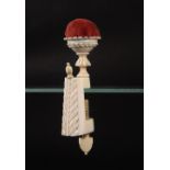 A 19th Century ivory sewing clamp, the rectangular frame carved with a leaf design below a finial (