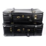 Asprey - London, and Fortnum and Mason, two black leather belted expandable suitcases, unused, of