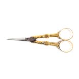 A pair of early 19th Century gold mounted scissors, tapering steel blades, the arms with leaf and