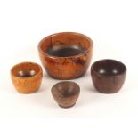 Four 19th Century wooden wool ball bowls, comprising a large lignum vitae example, 13cms, and