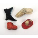 Four figural material pin cushions, comprising an 18th Century example as a shoe, silk worn in