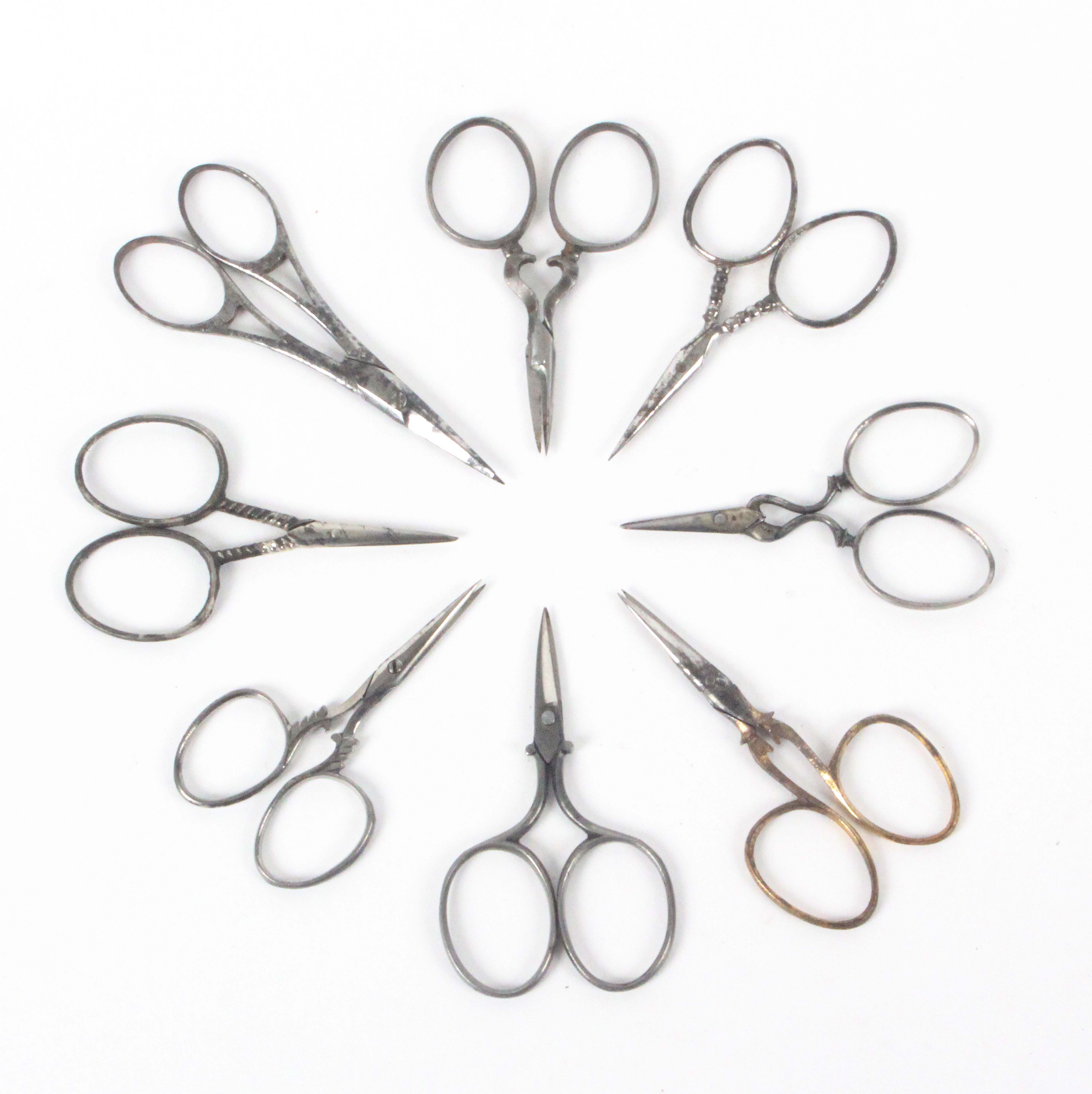 Eight pairs of delicate 19th Century steel scissors, including a pair with gilded handles, some with