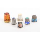 Six 20th Century thimbles comprising, a Bohemian glass example with gilt overlay, a mother of