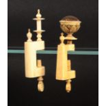 Two 19th Century ivory sewing clamps, both with rectangular frames surmounted by a finial, one below