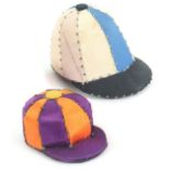Two jockey cap pin cushions, in pin stuck silk panels, the larger 19th Century, 3.5cms high, the