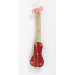 A Regency pin stuck pin cushion in coloured silks in the form of a guitar, the red and green silk