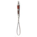 A silver ribbon threader, the handle embellished with two polished agates in the Scottish style,