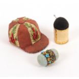 Three pin cushions, comprising a pin stuck jockey cap example in alternate panels of floral and