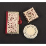 Two 19th Century ivory pin cushions and a needle book, comprising a disc form example with burnt
