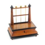 An unusual walnut, ebonised and brass mounted reel stand, circa 1860, the ogee moulded base fitted