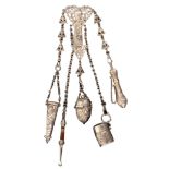 An English silver chatelaine, the hinged clip to a leaf scroll mount centred by a male head, with