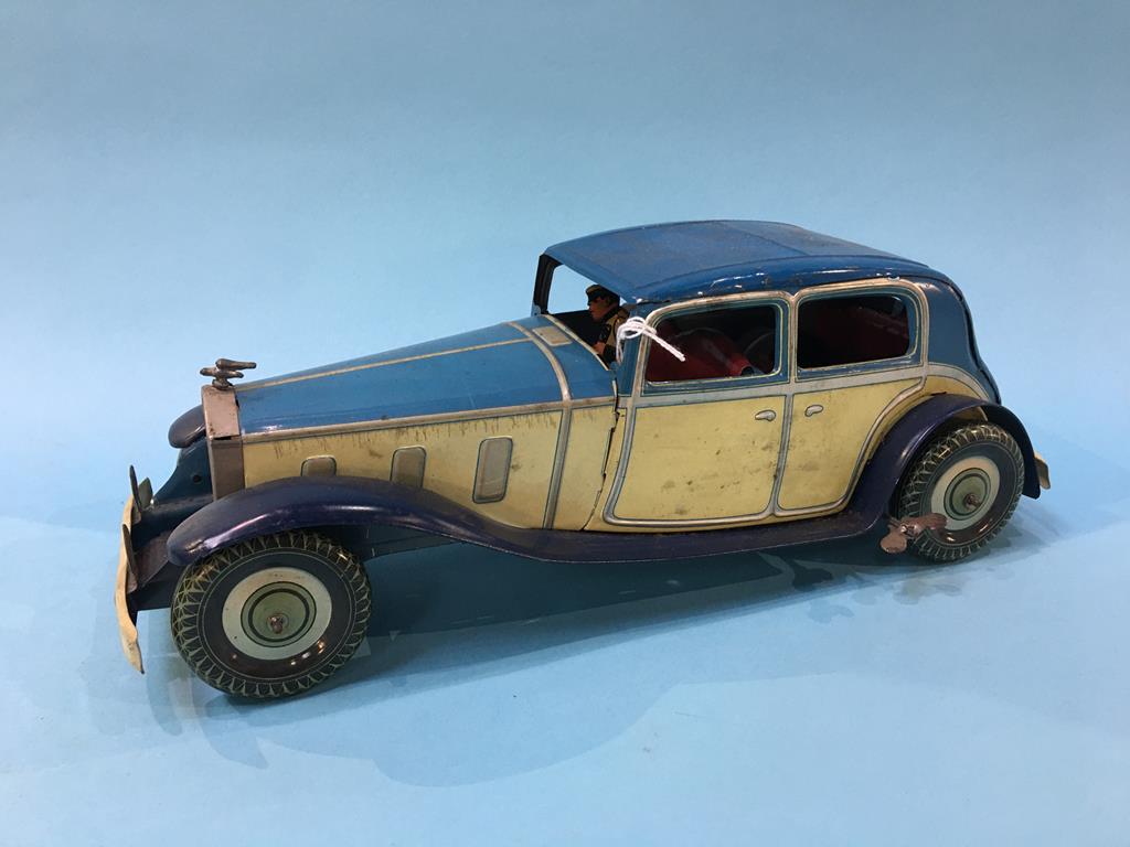 A clockwork tin plate model of a Rolls Royce, complete with chauffer, 'Made in England', 36 cm long
